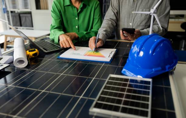 deux professionnels qui étudie un graphique sur une table pro avec des outils d'ouvriers