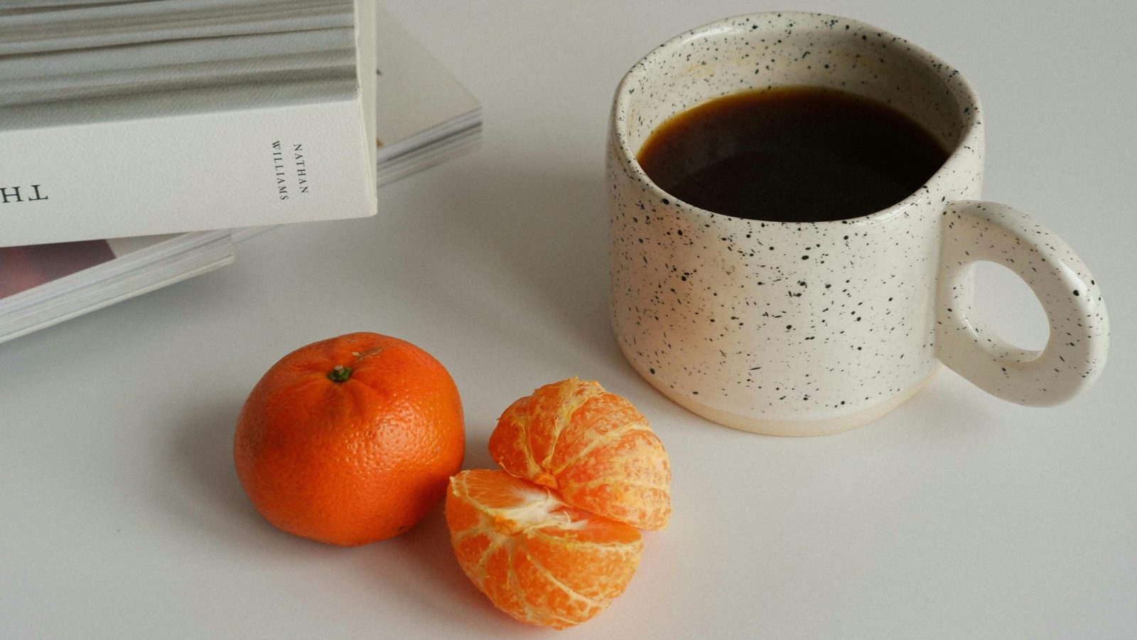 clémentine et tasse à café sur table blanche